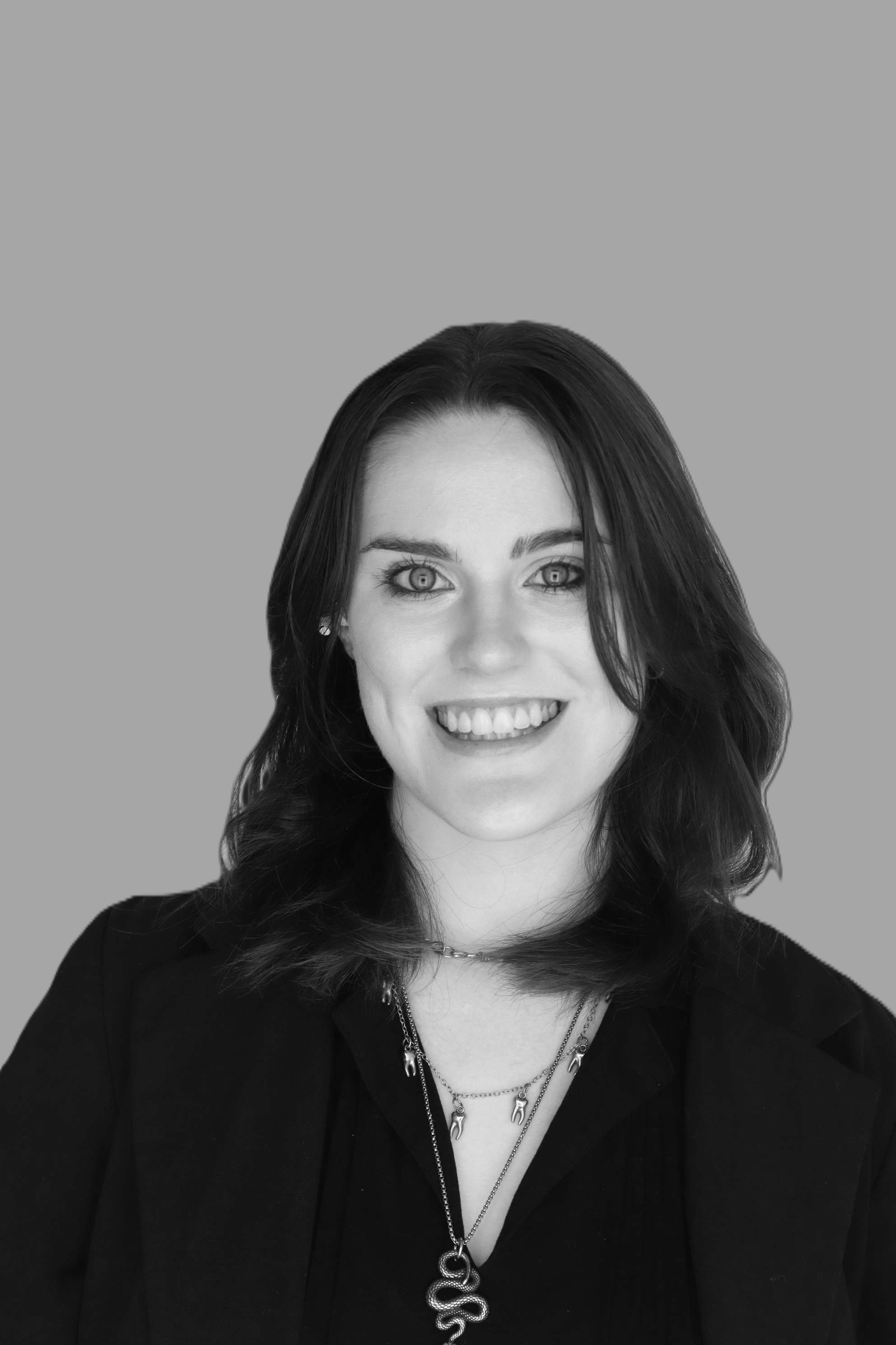 Professional man wearing glasses and dark shirt photographed in profile against a warm gradient background transitioning from green to red, conveying a modern and thoughtful aesthetic.